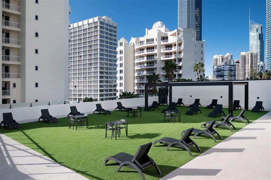 una zona erbosa con sedie, tavoli e edifici di Amazing suite with beach views at prime location a Gold Coast