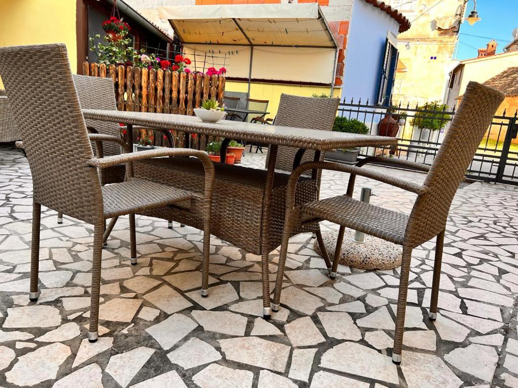 un tavolo e sedie seduti su un patio di Apartments Zukanovic a Fažana