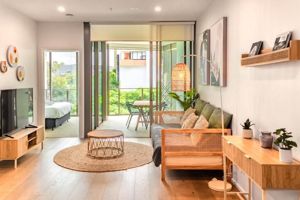 - un salon avec un canapé et une table dans l'établissement Brand New Riverside Designer 2BD apartment at West End, à Brisbane