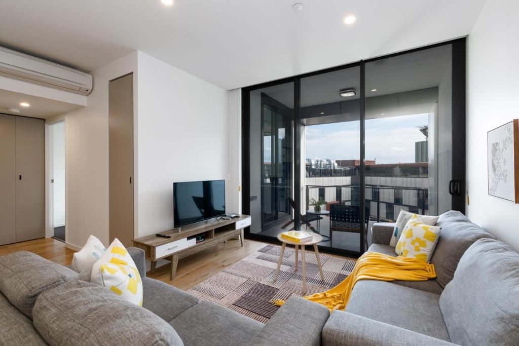 a living room with a couch and a television at Stylish 1BD Apt with Ideal Location in Southbank in Brisbane