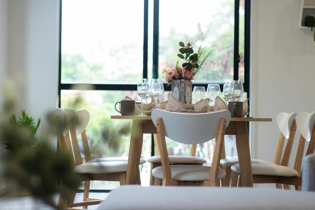 uma mesa de jantar com cadeiras e copos de vinho em Newly Furnished Spacious 3BR Townhouse at GC em Gold Coast