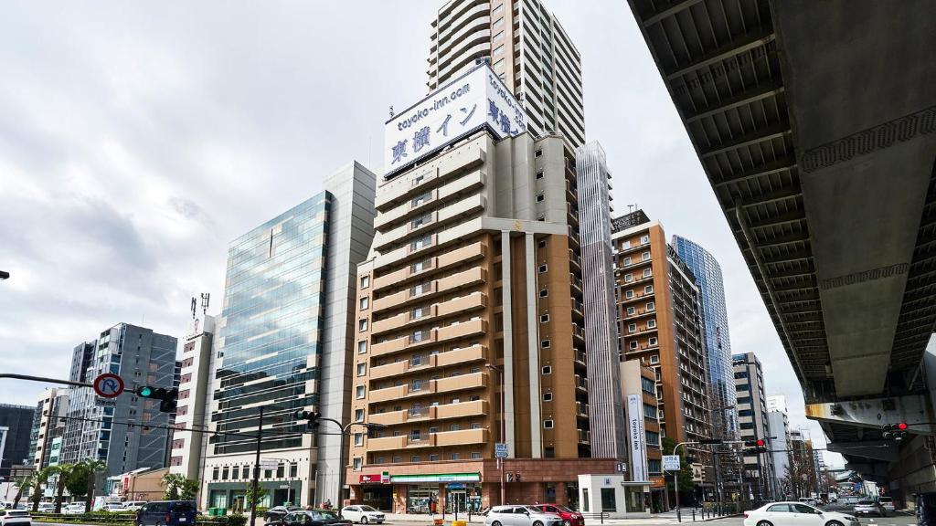 a tall building in the middle of a city at Toyoko Inn Osaka Taniyon Kosaten in Osaka