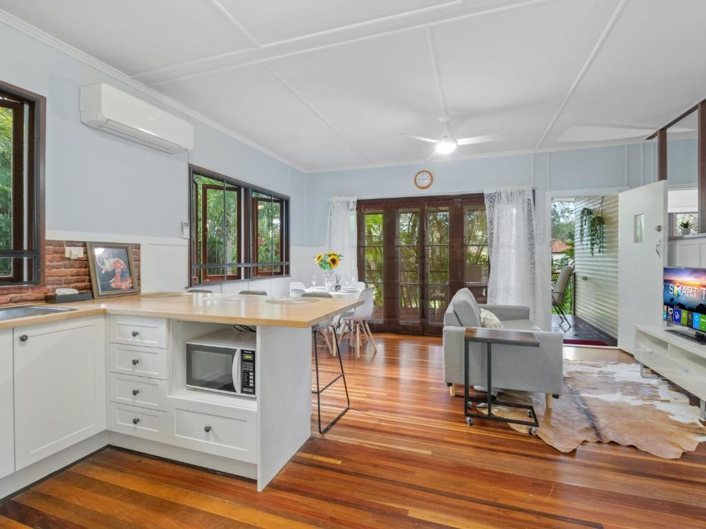 a kitchen with white cabinets and a table and chairs at Great value 3BD house at a convenient location in Brisbane