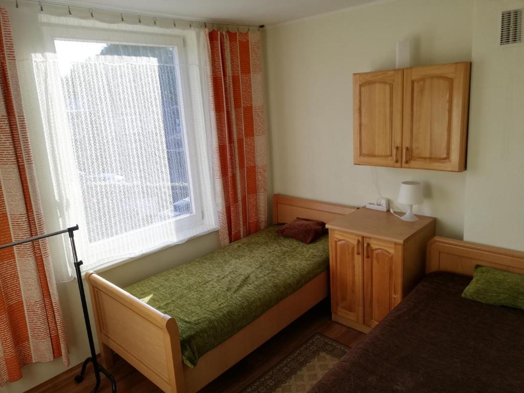 a small bedroom with a bed and a window at Šalia Birutės parko 3 in Palanga