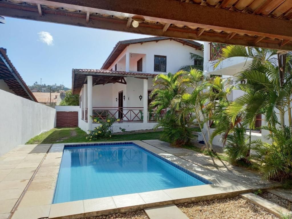 a swimming pool in front of a house at Casa Solaris in Aquiraz
