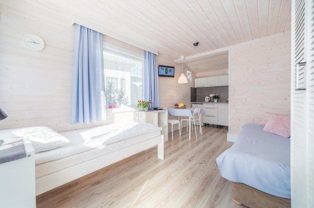 mały pokój z łóżkiem i kuchnią w obiekcie ASTORIA-Ruszel domki letniskowe w Dziwnowie