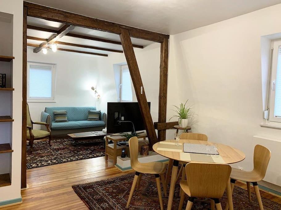 uma sala de estar com uma mesa e um sofá em CosyAttic em Saint-Louis
