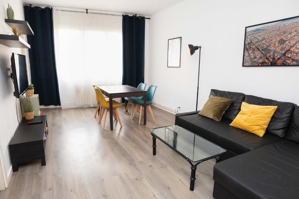 a living room with a black couch and a table at Apartment Carrer de Joan in Barcelona