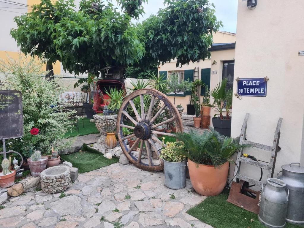 a garden with a woodenoked wheel and plants at rez de maisons in Avignon