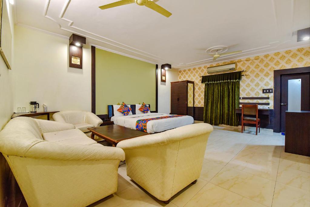 a living room with a couch and a bed at FabHotel Prime Surpin Palace in Kota