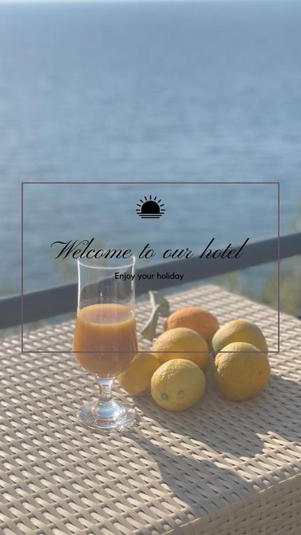 a glass of orange juice and lemons on a table at The Blue Horizon in Vlorë
