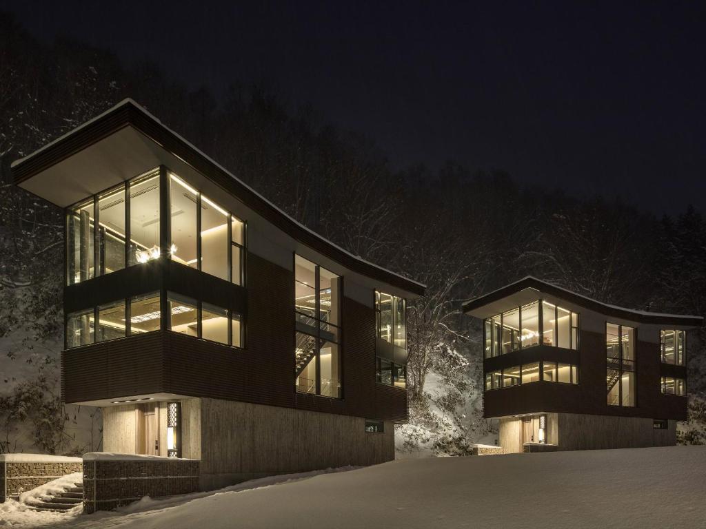 Una casa en la nieve por la noche en AYA Villa en Niseko