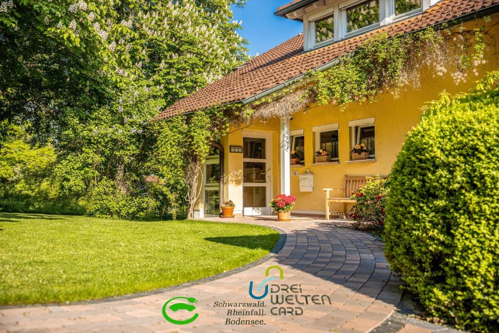 a house with a brick walkway in front of a yard at Haus Ahorn in Bad Dürrheim