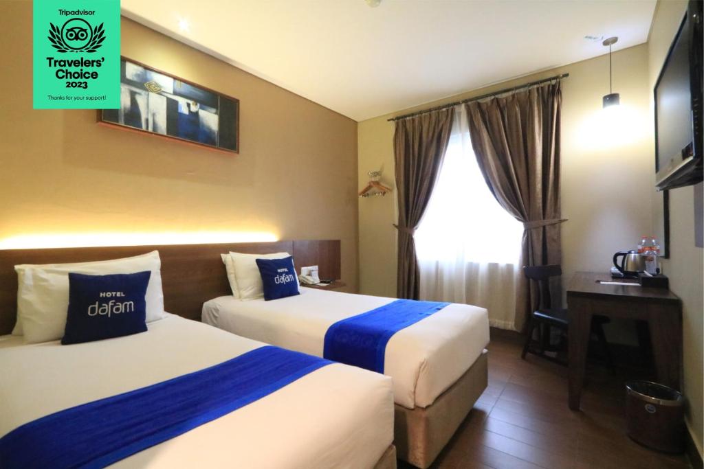 Postel nebo postele na pokoji v ubytování Dafam Hotel Cilacap