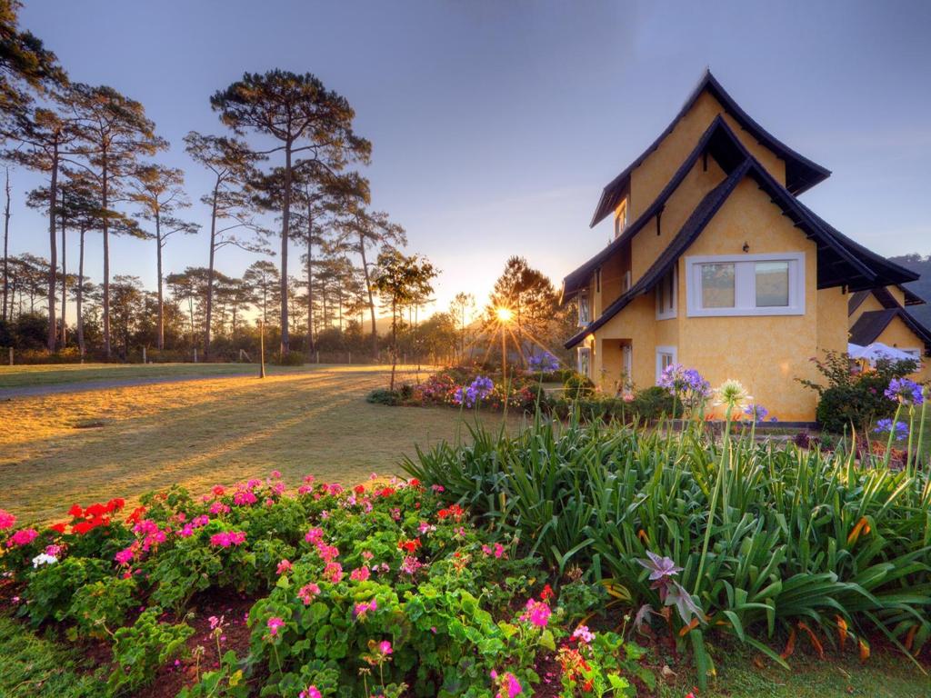 a house with flowers in front of it at Binh An Village Resort in Da Lat