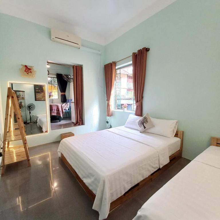 a bedroom with a white bed and a mirror at Camelia Homestay in Hanoi