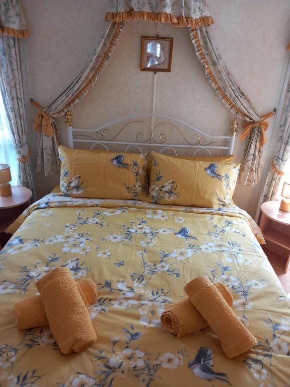 a bedroom with a bed with yellow and blue flowers at Cosy comfort in Ingoldmells