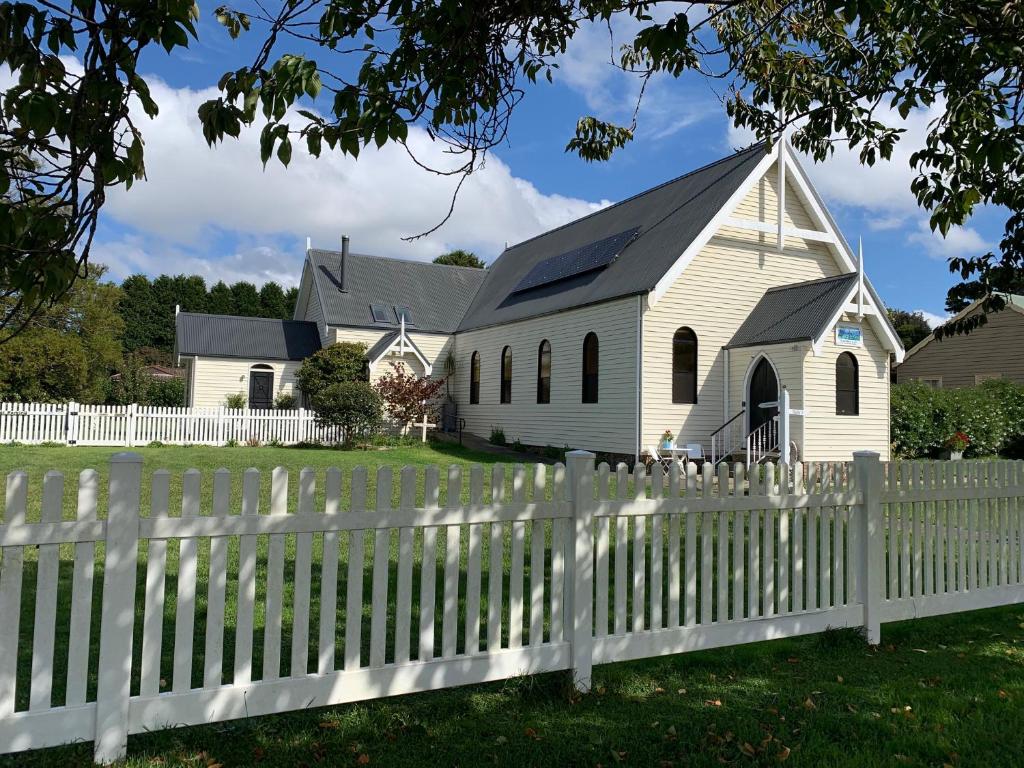 a white church behind a white picket fence at Church Conversion in Robertson