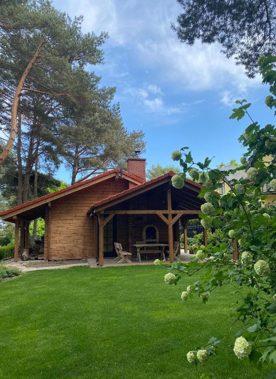 a log cabin with a picnic table in a yard at Klimatyczny domek z drewna nad morzem in Debina
