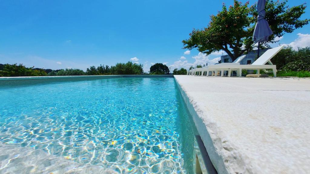 洛科羅通的住宿－Casale Marangi，一座房子前面的蓝色海水游泳池