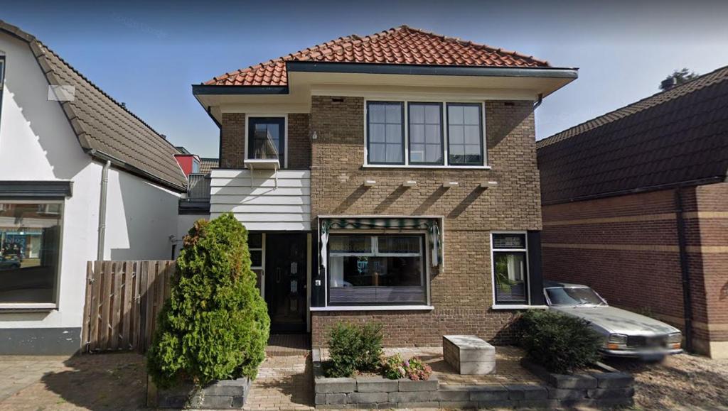 una casa di mattoni con una macchina parcheggiata di fronte di City centre apartment ad Apeldoorn