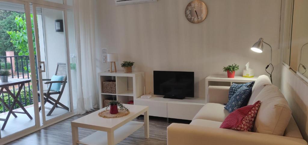 ein Wohnzimmer mit einem Sofa und einem TV in der Unterkunft ApartamentoCalellaClos in Calella de Palafrugell