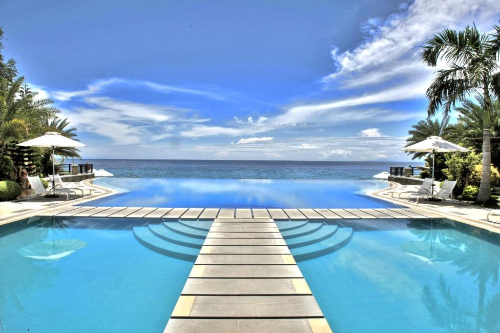 a swimming pool with the ocean in the background at Acuatico Beach Resort & Hotel Inc. in San Juan