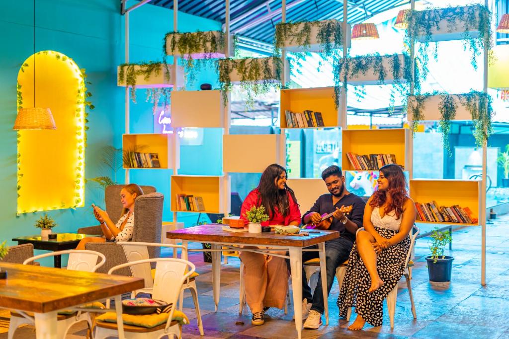 a group of people sitting at a table in a cafe at The Hosteller Goa, Candolim in Candolim