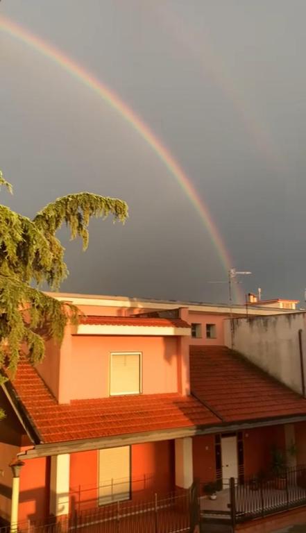 un arco iris en el cielo sobre una casa en Denda House, en Mariglianella