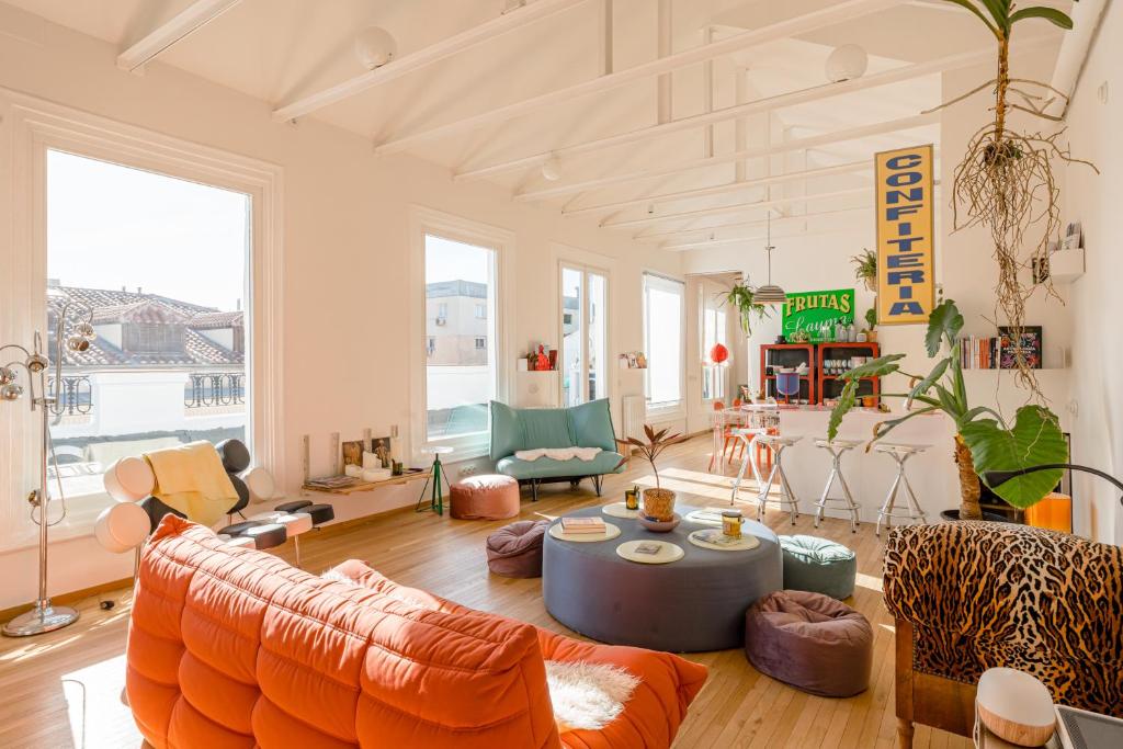 a living room with an orange couch and chairs at Pop-Zen Penthouse Madrid in Madrid