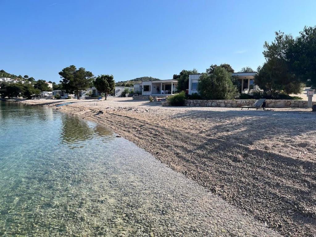 a sandy beach with a house in the background at BUQEZ ECO RESORT - Beach Villas 2 and 8 - Seaview, new wifi! in Drage