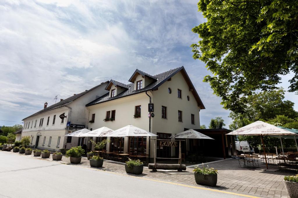 a large white building with umbrellas in front of it at Pr'Finzgar in Brezje