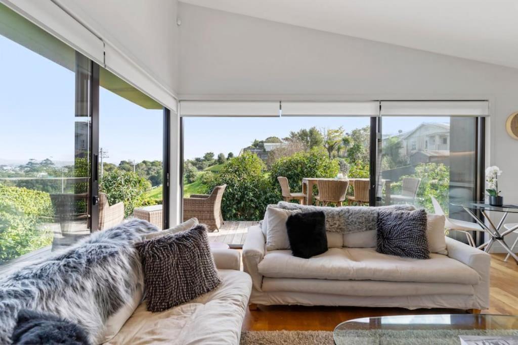 a living room with two couches and a large window at Amazing Western Springs position in Auckland