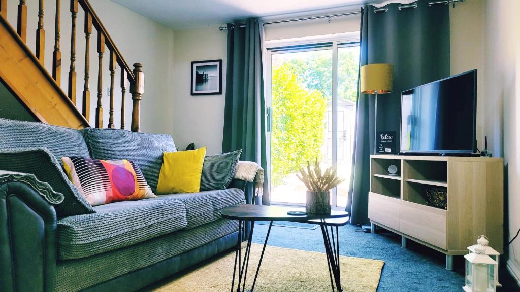 a living room with a couch and a tv at Modern 2 bed house- Free parking and close to the centre in Bristol