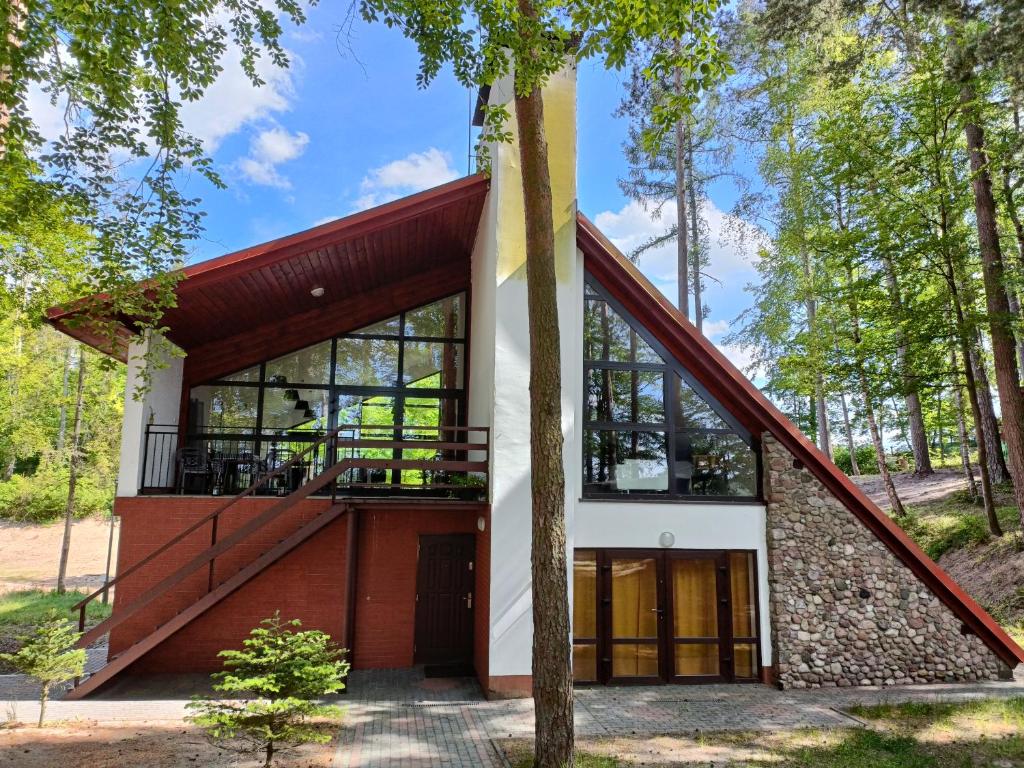 a house in the woods with a large window at Instytut Wypoczynku in Sulęczyno