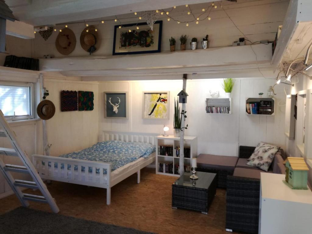 a bedroom with a bed and a ladder in a room at Zurück zur Natur - Urlaub im Zirkuswagen, Sommeratelier oder Schindelwagen in Adenbach