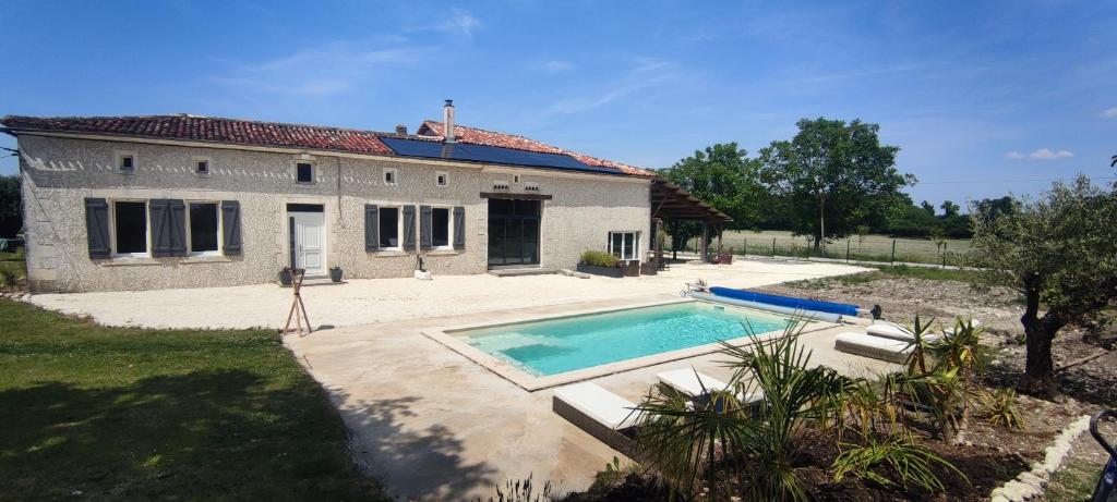 a house with a swimming pool in front of it at Gîte avec piscine au cœur de la campagne 
