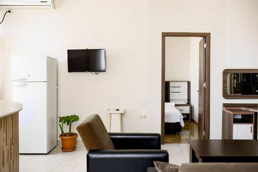 a living room with a couch and a tv on a wall at Apartments 37B in Batumi