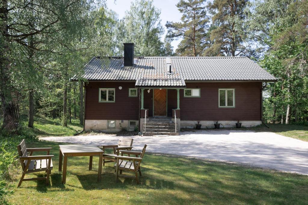een huis met een tafel en stoelen ervoor bij Villa Signell Förby in Särkisalo