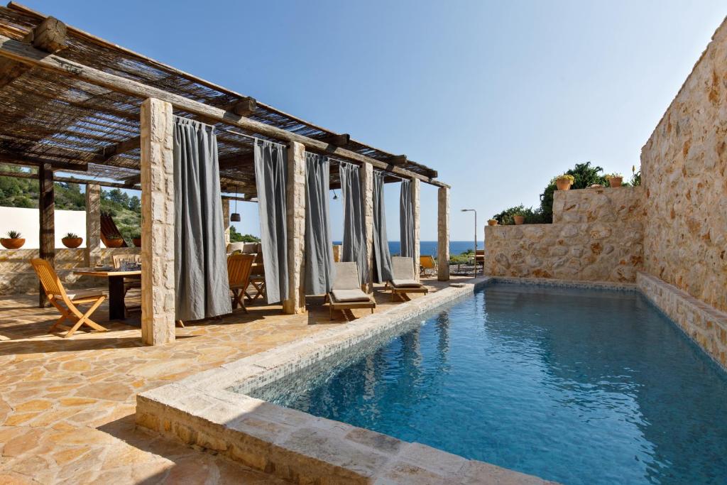 a pool with lounge chairs next to a building at Villa Vito in Hvar