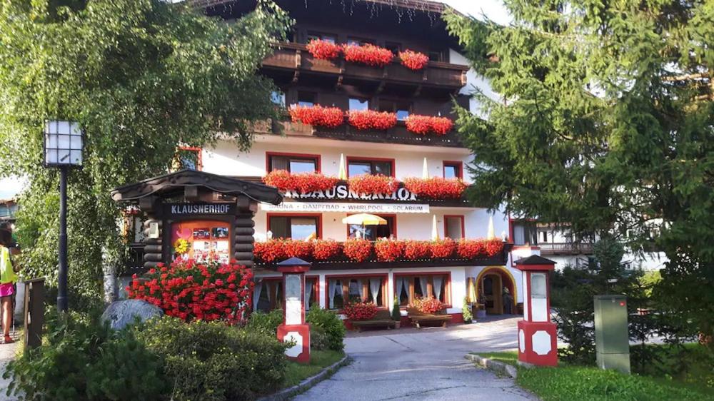 un hotel con fiori di fronte a un edificio di Landhaus Klausnerhof Hotel Garni a Seefeld in Tirol