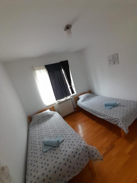 a room with two beds and a wooden floor at Apartment Ken in Surčin