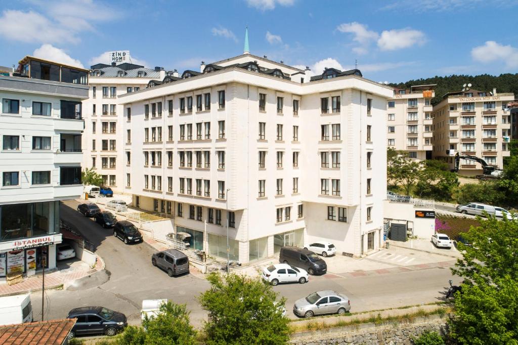 ein weißes Gebäude mit Autos auf einem Parkplatz in der Unterkunft Zin D Sefin Aparts in Istanbul
