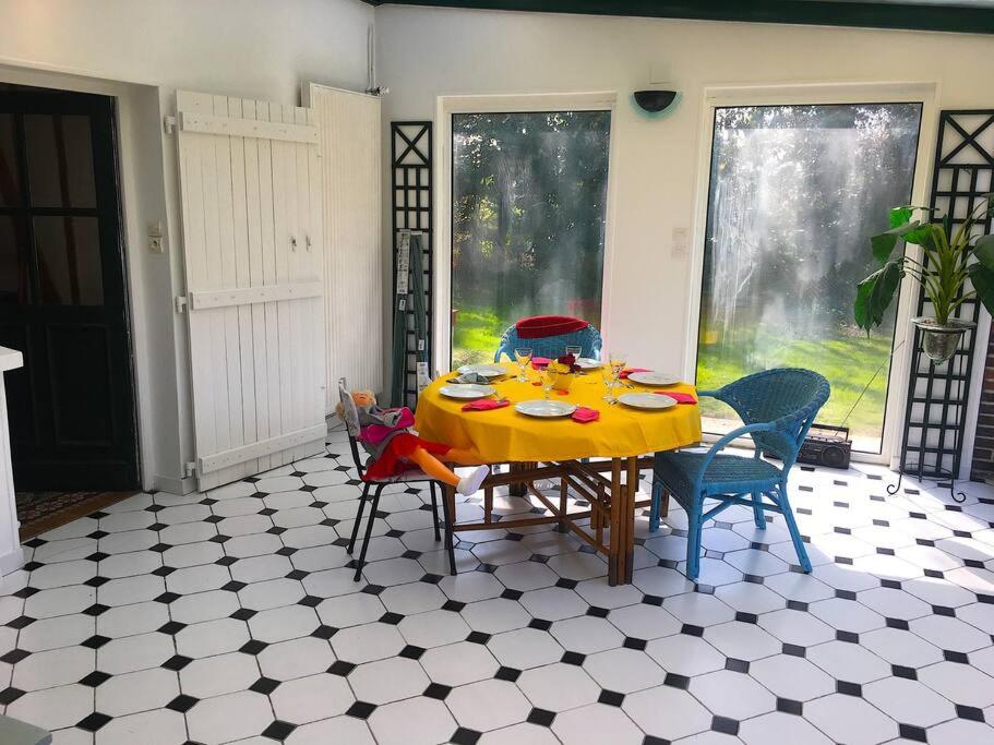een eettafel met stoelen en een gele tafelkleed bij Happiness la maison du bien-être (100 m2) 
