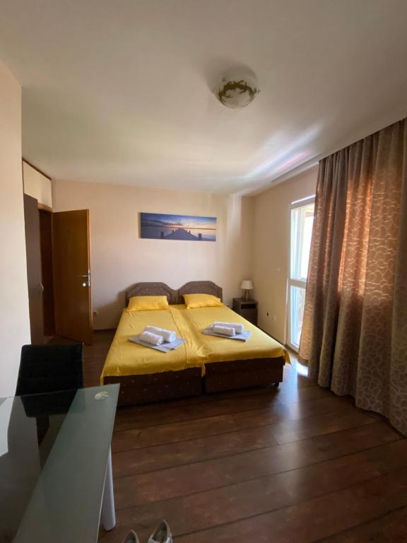 1 dormitorio con cama, mesa y ventana en Apartments and Rooms Grande Casa en Bar