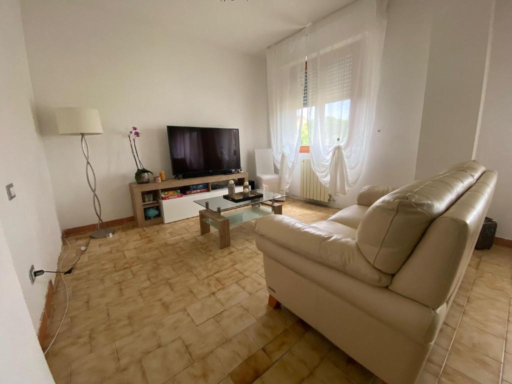sala de estar con sofá y TV en House Cooper - 2 Min Dal Mare, en Marina di Carrara