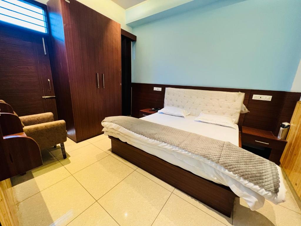 Bajaura的住宿－Hotel Anjum Regency，一间卧室配有一张床和一把椅子