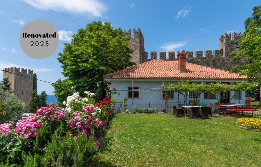 a house with a garden with flowers in front of it at Walls of Piran Apartments and Rooms in Piran