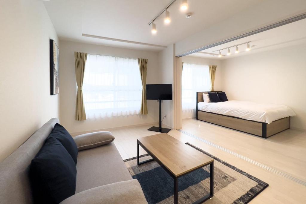 uma sala de estar com um sofá e uma cama em toggle BUNKYO KORAKUEN em Tóquio