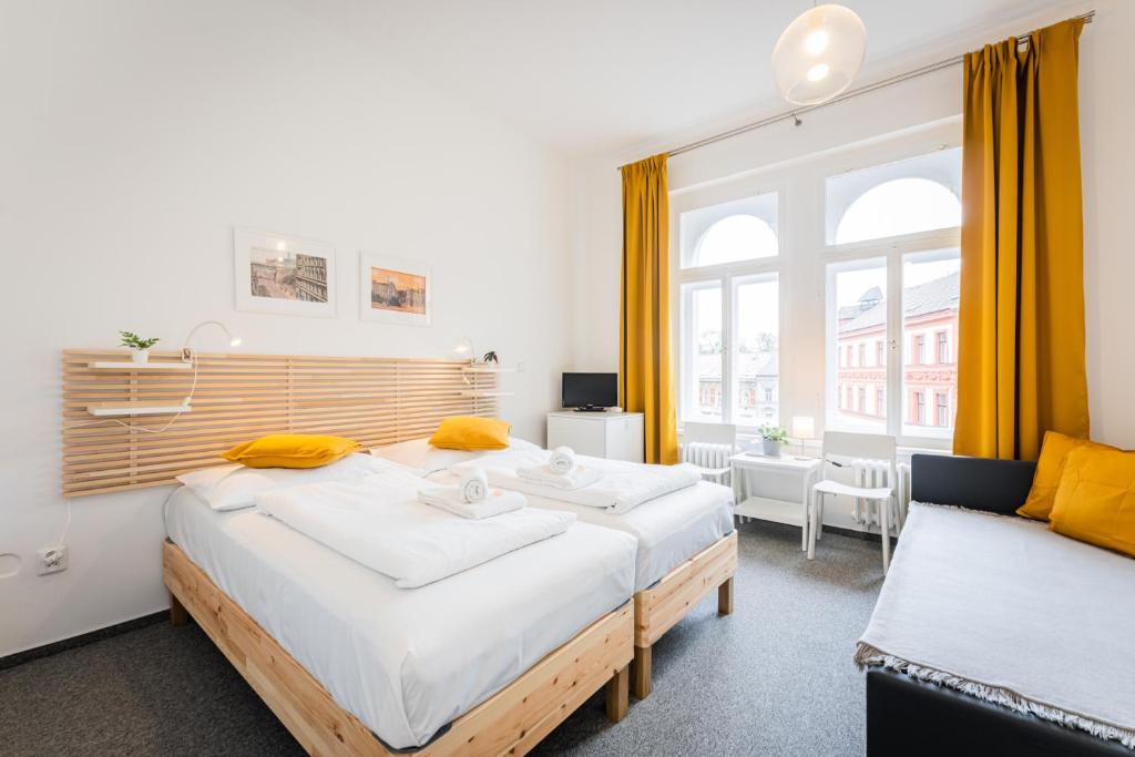 a bedroom with two beds and a couch at Self-service Hotel Ostaš Praha in Prague